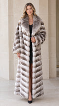 Front view of woman wearing full-length grey ombre chevron faux fur maxi coat