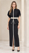 Front full-length view of model wearing black two-piece set with peplum top, white trim, and maxi skirt