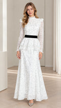 Front view of model wearing white floral tiered peplum maxi dress with black velvet waistband