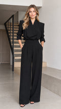 Front full view of woman wearing black tailored wrap-front wide-leg jumpsuit