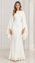 Front view of model wearing white boat neck maxi gown with lace trim cape sleeves