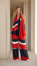 Front full-length view of woman wearing red, navy, and white color block halter top and wide-leg pants set