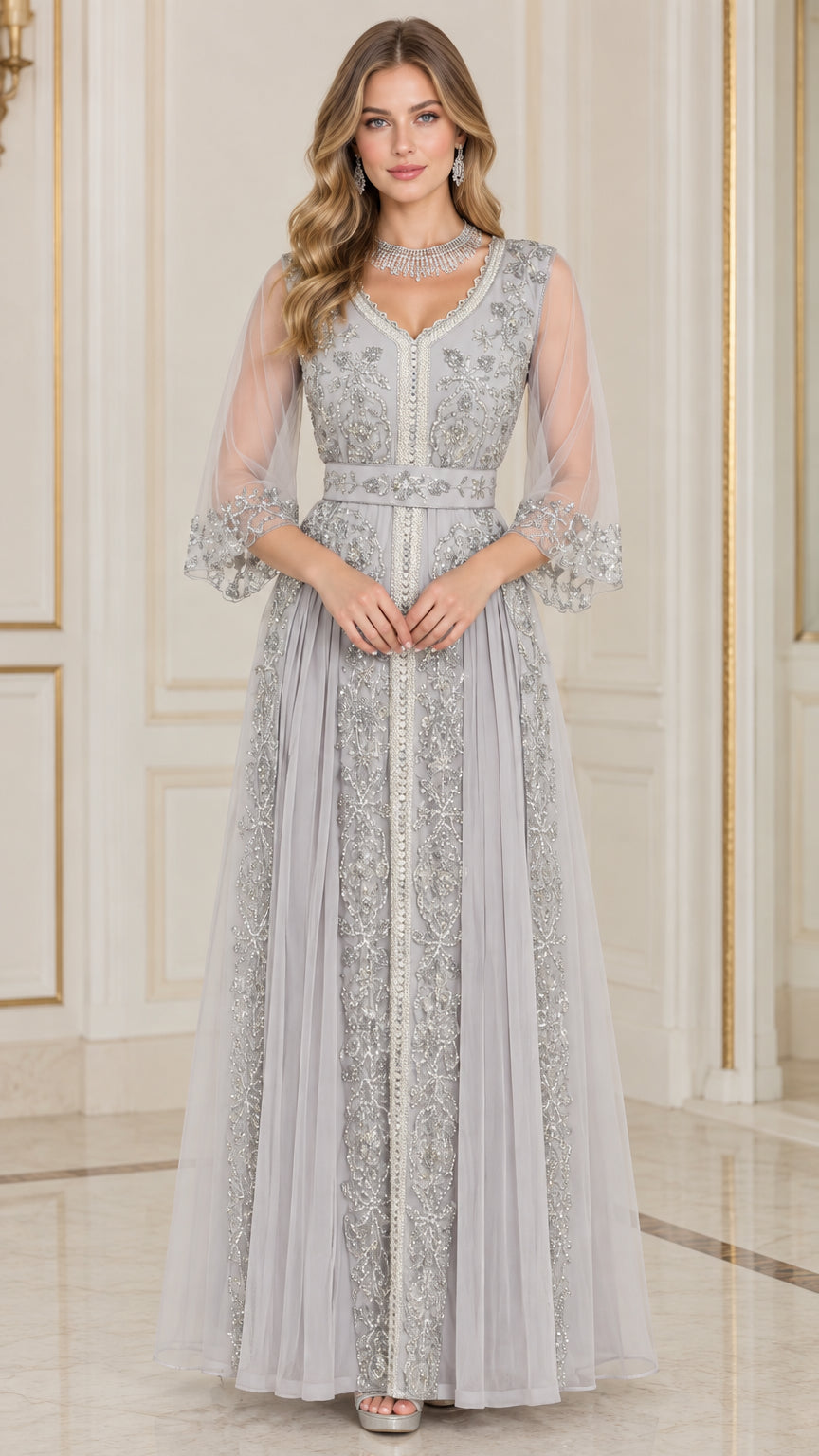 Front full-length view of woman in silver grey embroidered beaded V-neck evening gown