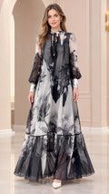 Front full-length view of black and white floral print chiffon tiered maxi dress