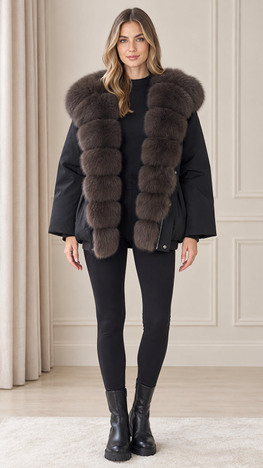 Front view of model wearing black plush hooded winter parka coat with black leggings and boots