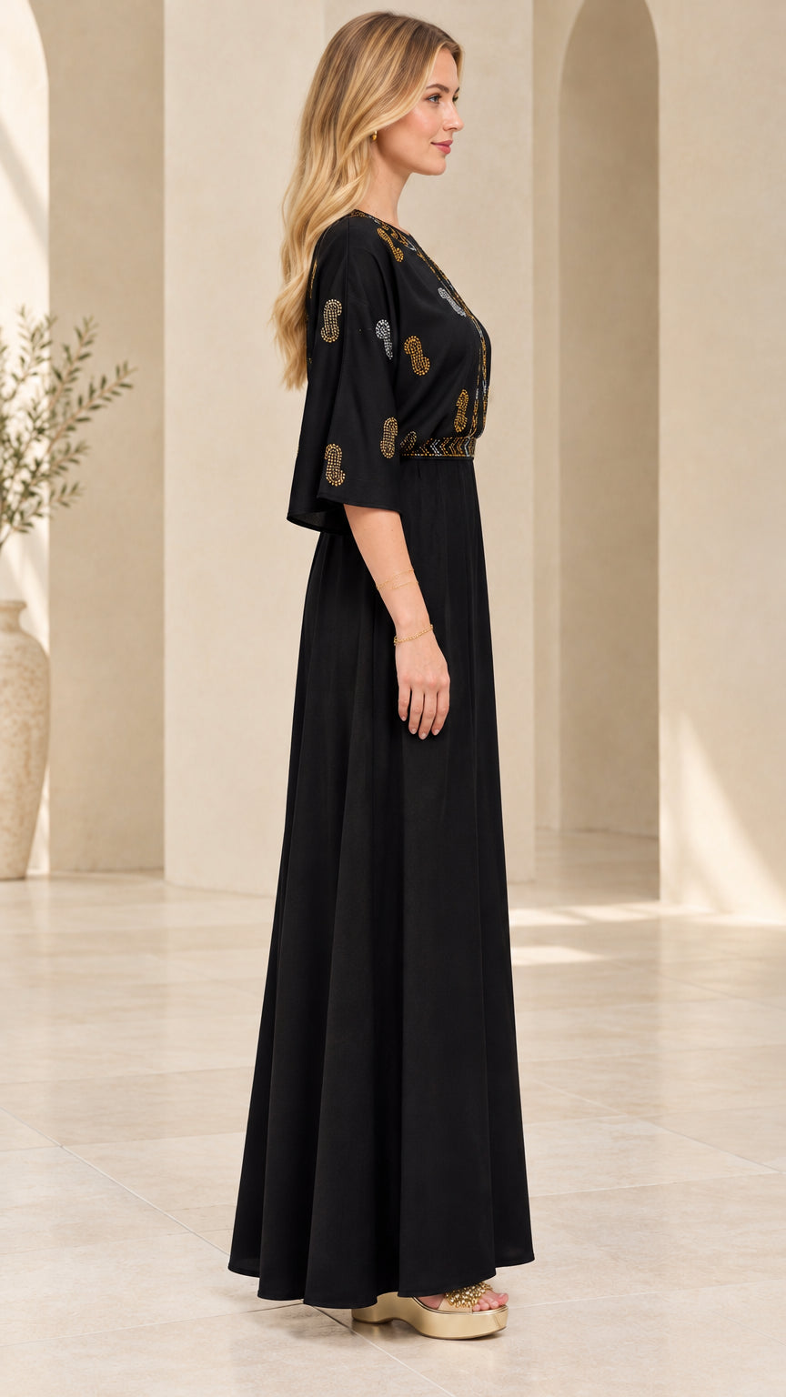 Side angle view of model in black embellished maxi dress