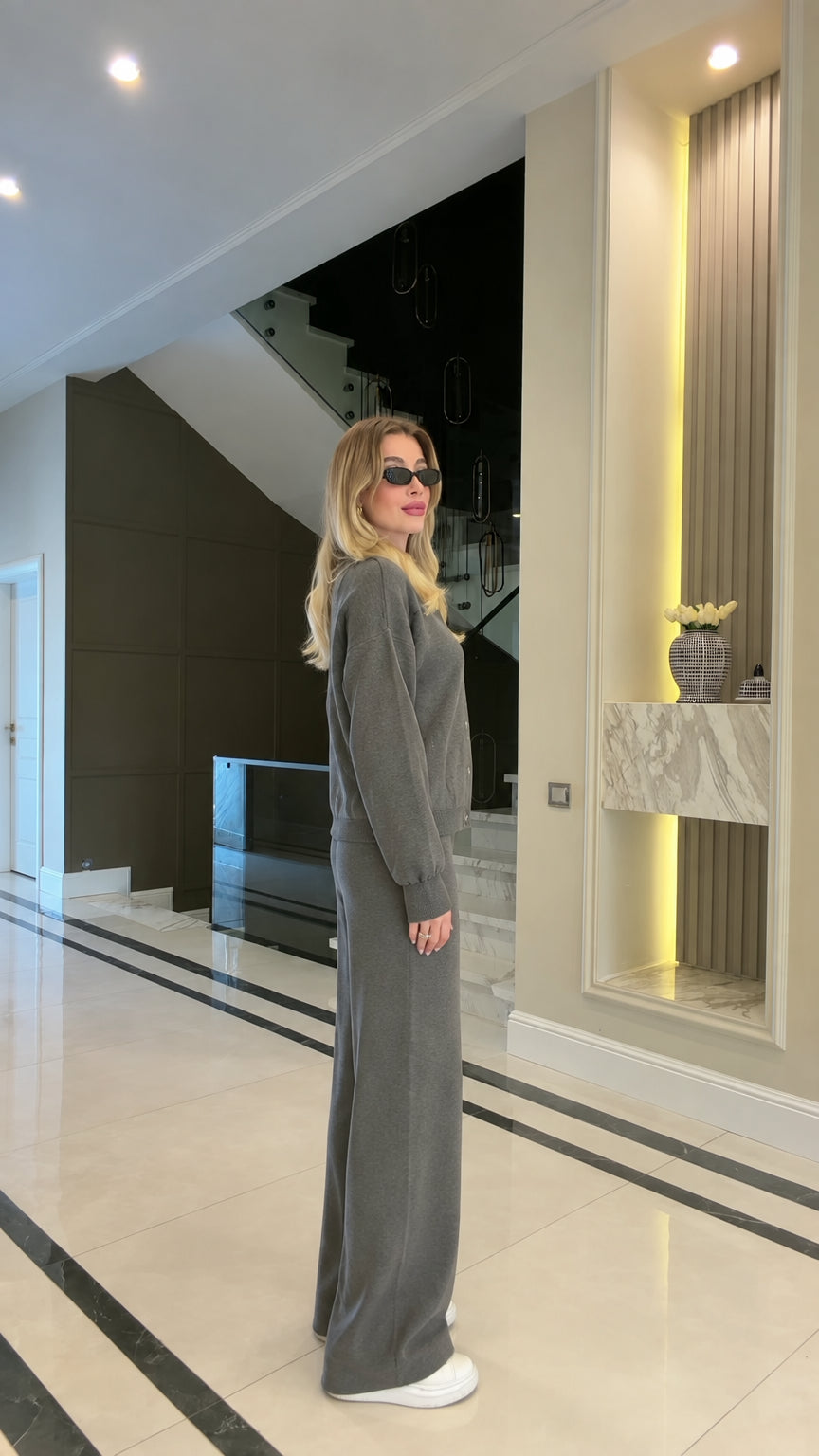 Side full view of woman wearing charcoal grey collared zip sweatshirt and wide-leg sweatpants