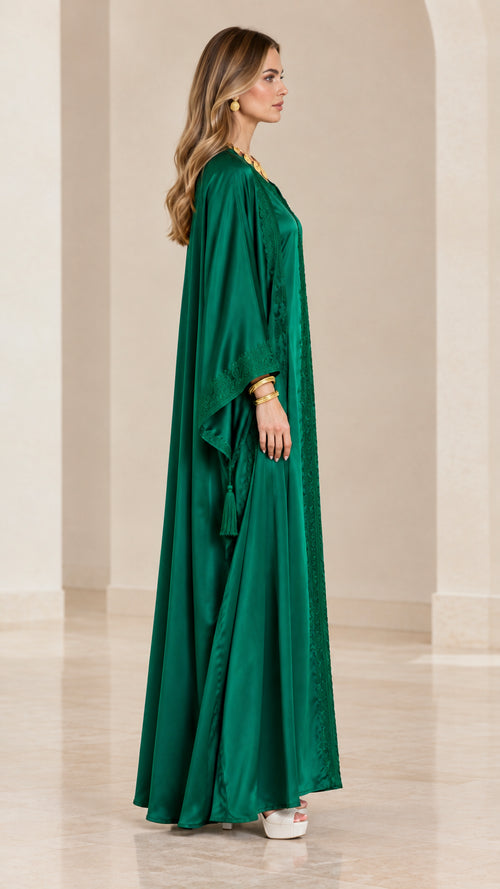 Side profile view of emerald green satin kaftan dress showing flowing silhouette
