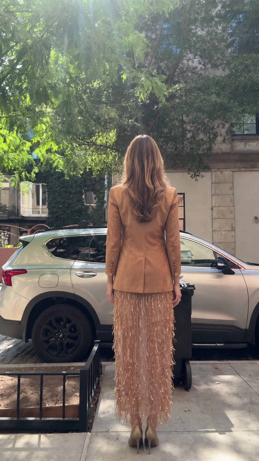 Back view of model wearing structured blazer and tassel skirt set