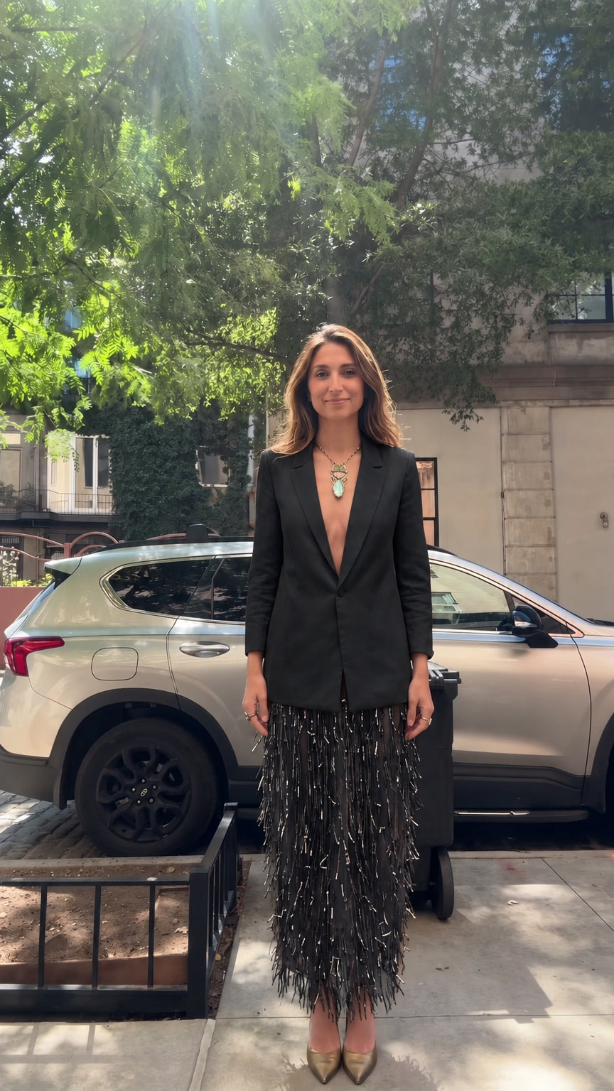 Model wearing classic black tailored single-button blazer and black fringe skirt