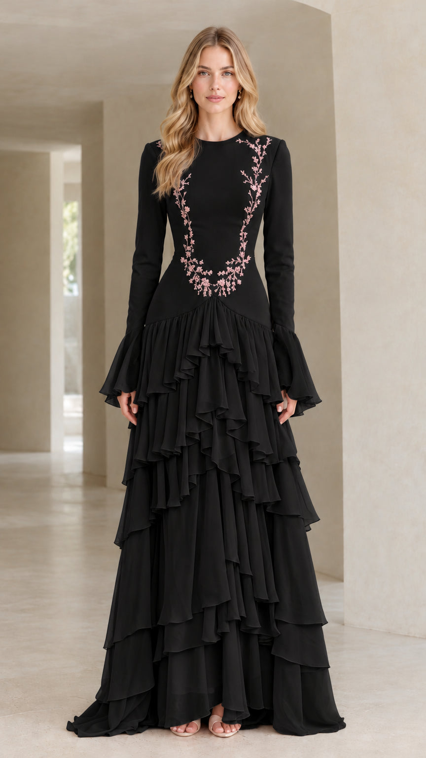 Front full view of woman wearing black embroidered tiered ruffle long sleeve maxi gown