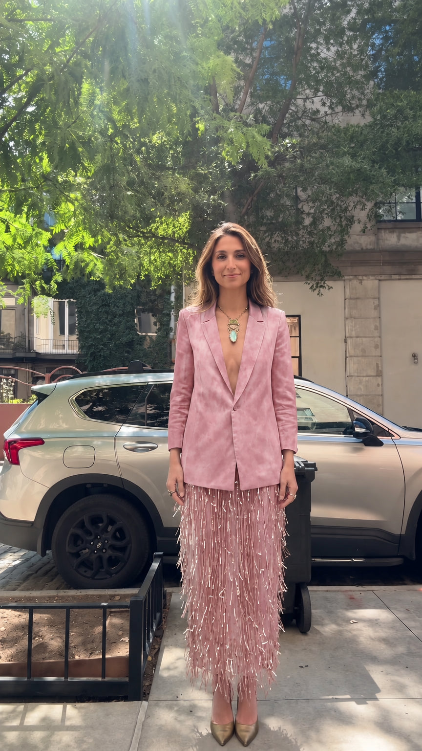Model wearing dusty pink tailored blazer and matching pink fringe skirt set