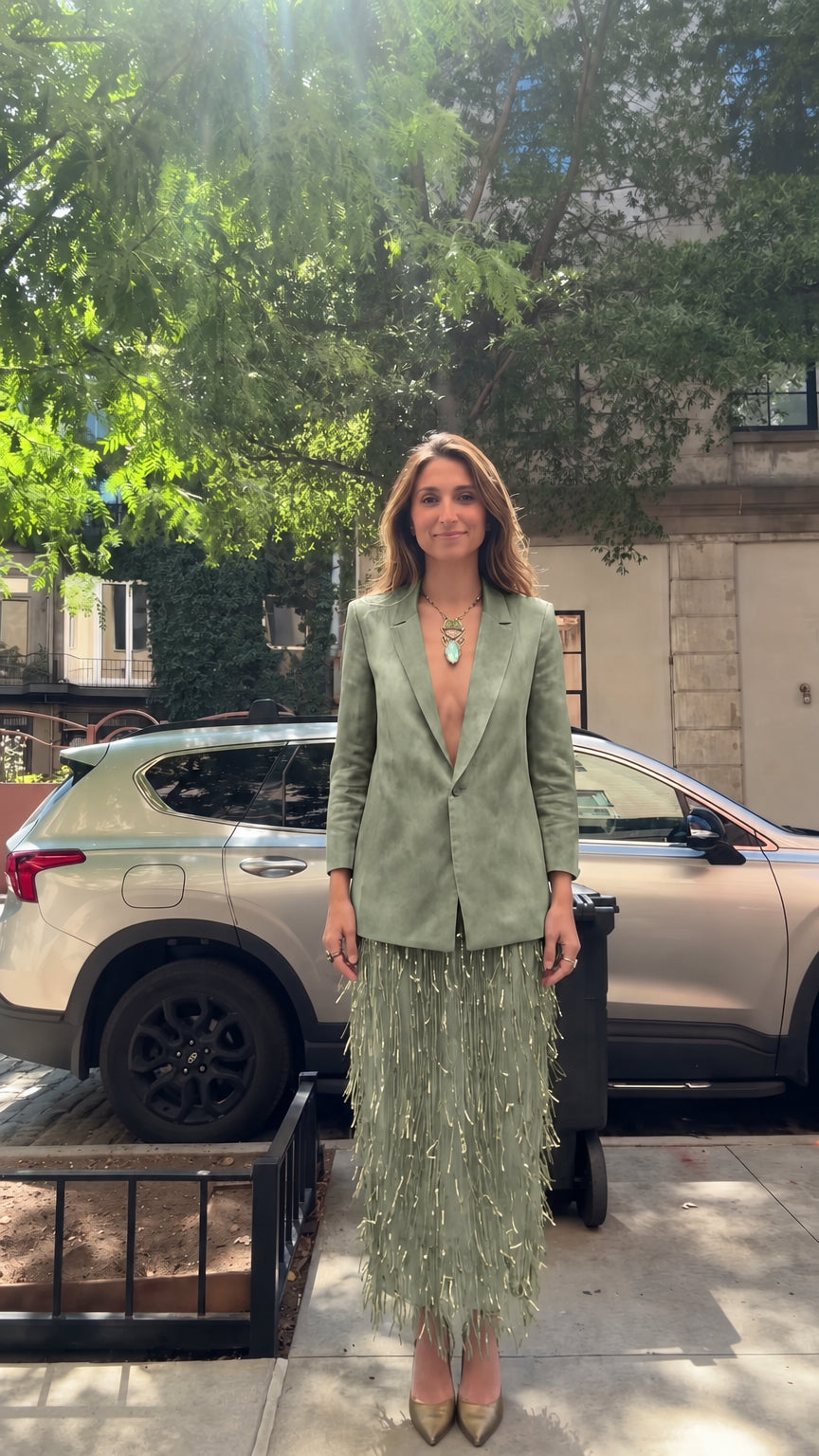 Model wearing sage green tailored blazer and matching sage fringe skirt set