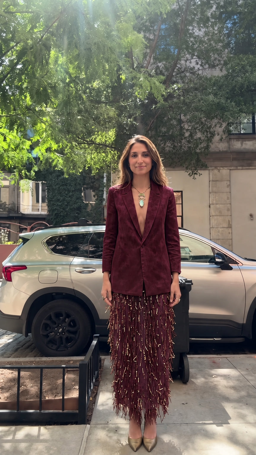 Model wearing rich burgundy tailored blazer and matching wine red fringe skirt set